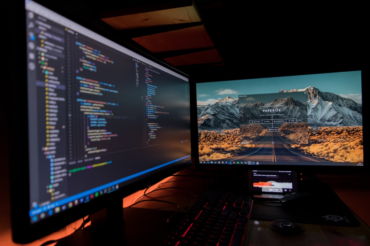 Two monitors displaying code in a professional developer workspace setup