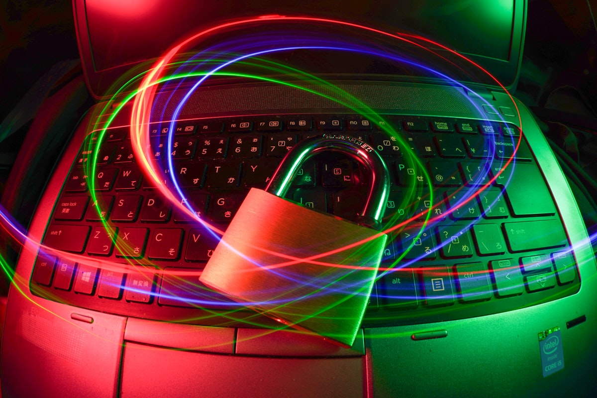 A padlock resting on a laptop keyboard with glowing digital light trails, representing cybersecurity and data protection