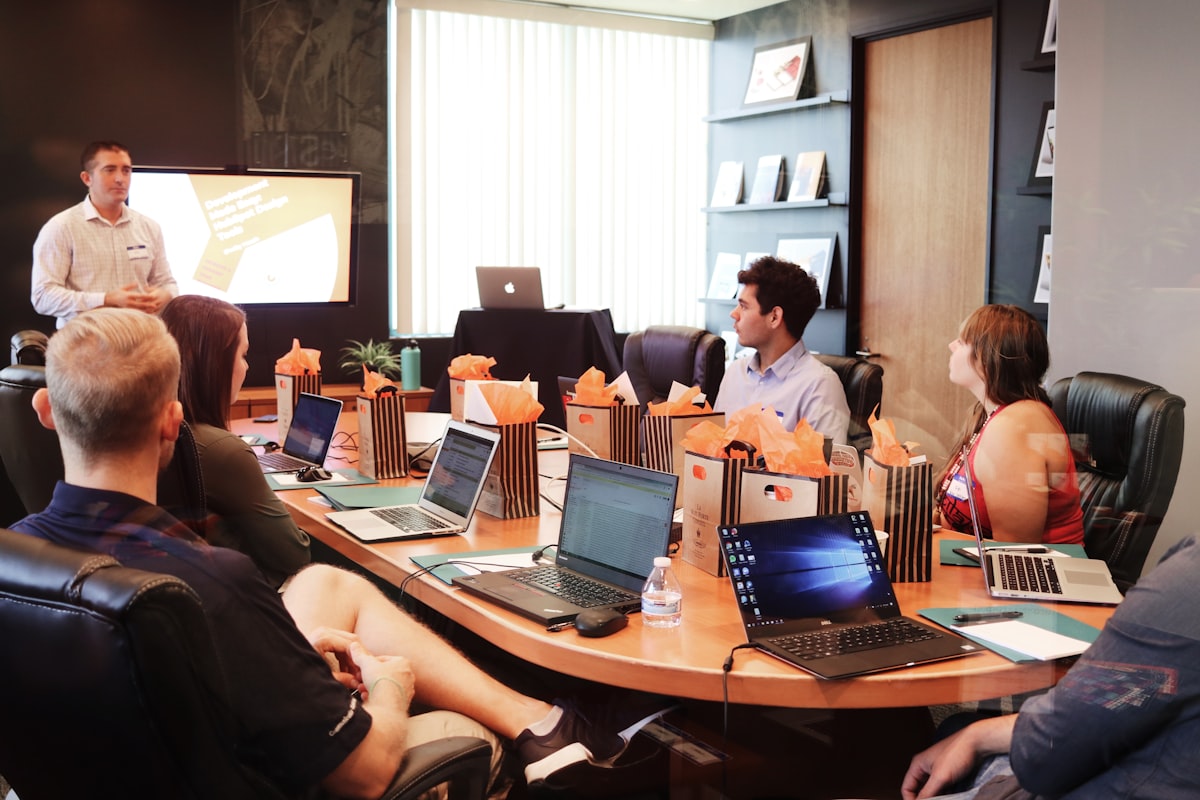 Business strategy presentation to a team seated with laptops, representing enterprise decision-making on AI deployment partners